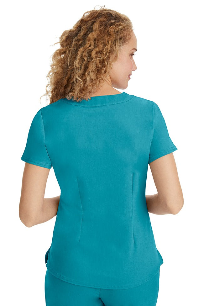 A young LPN wearing a Purple Label Women's Jane V-Neck Scrub Top in Teal featuring a medium center back length of 26.5".
