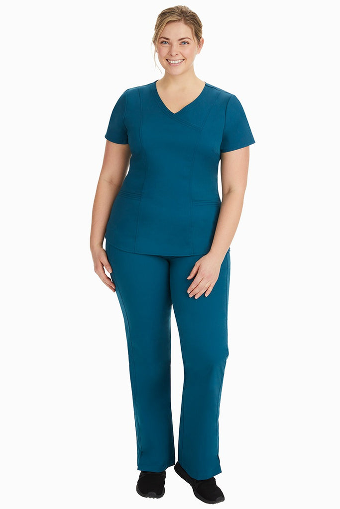 A young female nurse wearing a Women's Jordan Crossover Scrub Top from Purple Label by Healing Hands in Caribbean.