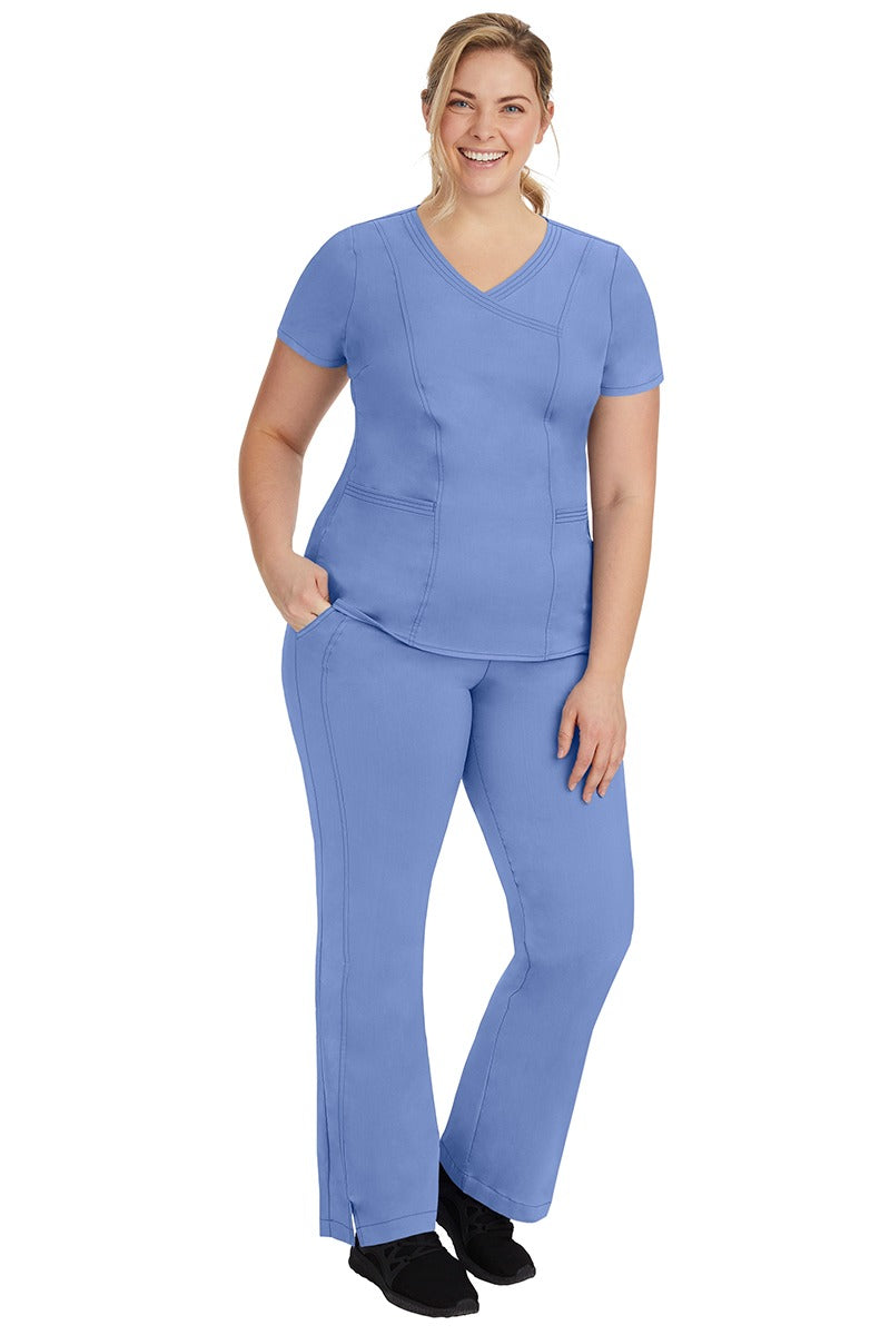 A young female nurse wearing a Women's Jordan Crossover Scrub Top from Purple Label by Healing Hands in Ceil.