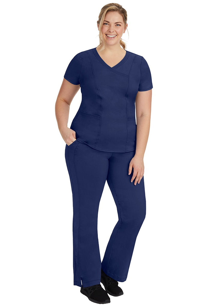A young female nurse wearing a Women's Jordan Crossover Scrub Top from Purple Label by Healing Hands in Navy.