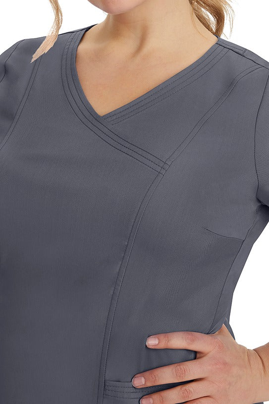 A young healthcare professional wearing a Purple Label Women's Jordan Crossover Top in Pewter featuring triple needle stitching details throughout.