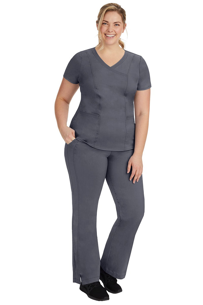 A young female nurse wearing a Women's Jordan Crossover Scrub Top from Purple Label by Healing Hands in Pewter.