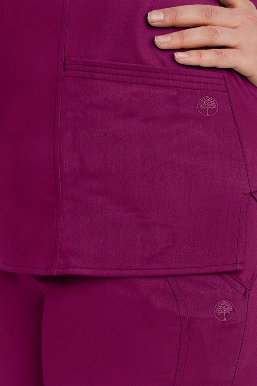 A young female RN wearing a Purple Label Women's Jordan Crossover Top in Wine featuring 2 front patch pockets.