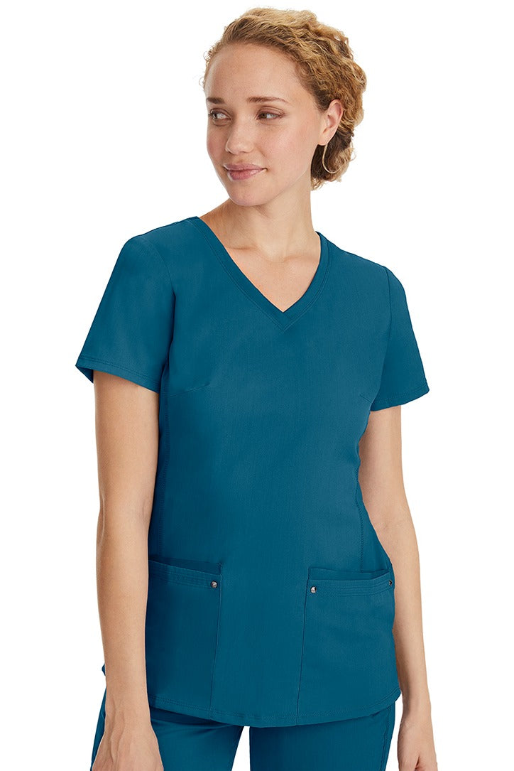 A lady nurse wearing a Purple Label Women's Juliet Yoga Scrub Top in Caribbean  featuring a super comfortable stretch fabric made of 77% polyester/20% rayon/3% spandex.