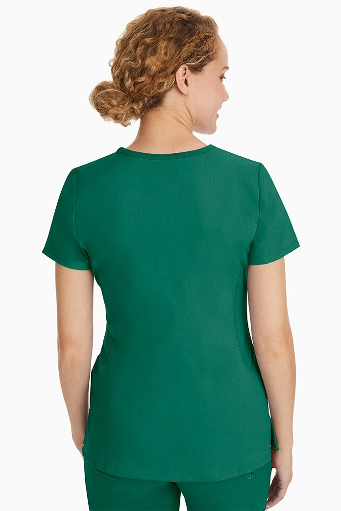 A female CNA wearing a Purple Label Women's Juliet Yoga Scrub Top in Hunter Green featuring a medium center back length of 24".