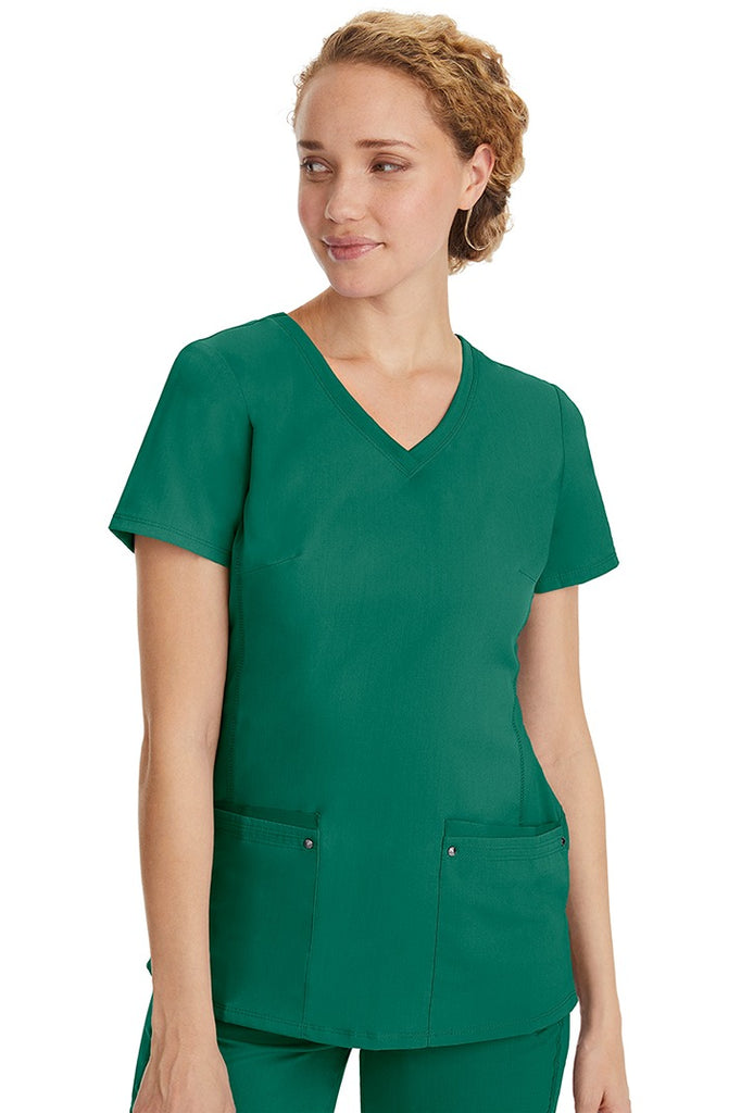 A lady nurse wearing a Purple Label Women's Juliet Yoga Scrub Top in Hunter Green featuring a super comfortable stretch fabric made of 77% polyester/20% rayon/3% spandex.