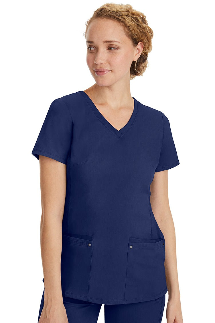 A lady nurse wearing a Purple Label Women's Juliet Yoga Scrub Top in Navy featuring a super comfortable stretch fabric made of 77% polyester/20% rayon/3% spandex.