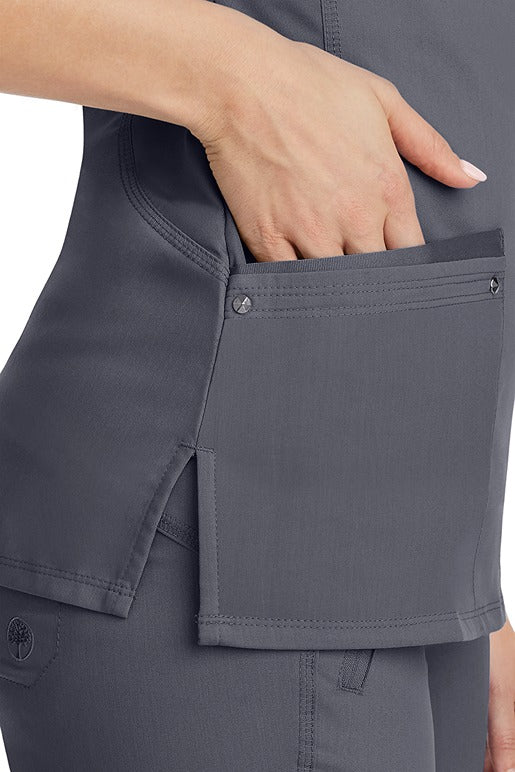 A young woman wearing a Women's Juliet Yoga Scrub Top from Purple Label by Healing Hands in Pewter featuring side slits for additional range of motion.