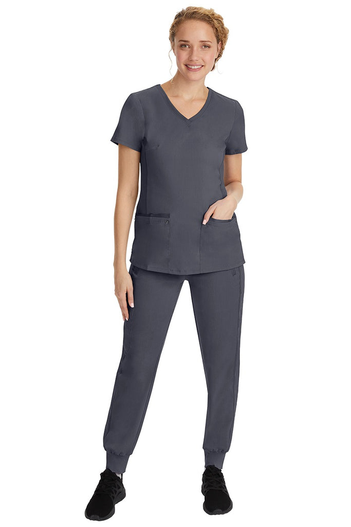 A young female nurse wearing a Purple Label Women's Juliet Yoga Scrub Top by Healing Hands in Pewter featuring a v-neckline.