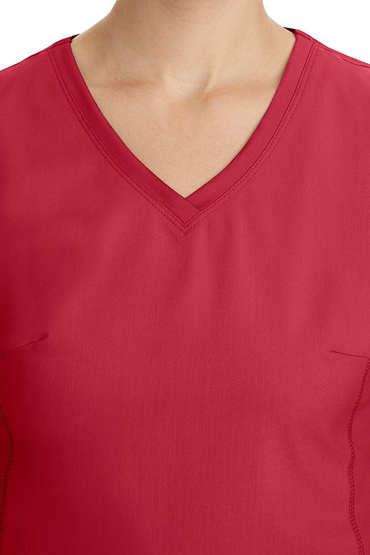 A young healthcare professional wearing a Purple Label Women's Juliet Yoga Scrub Top in Red  featuring a modern fit.