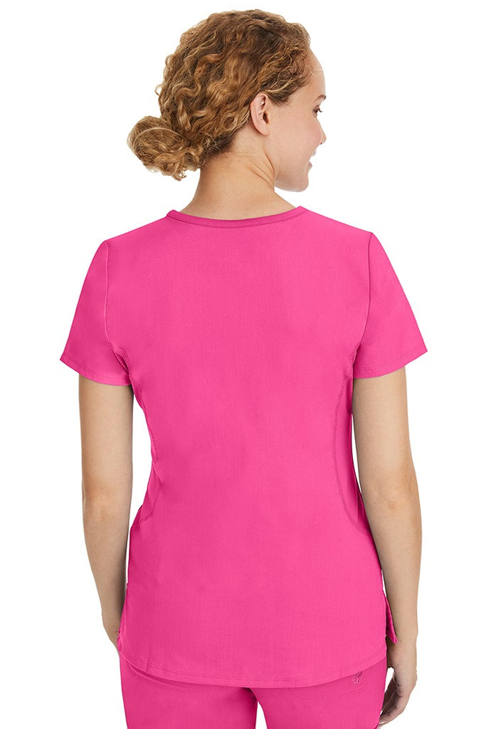 A female CNA wearing a Purple Label Women's Juliet Yoga Scrub Top in Shocking Pink featuring a medium center back length of 24".