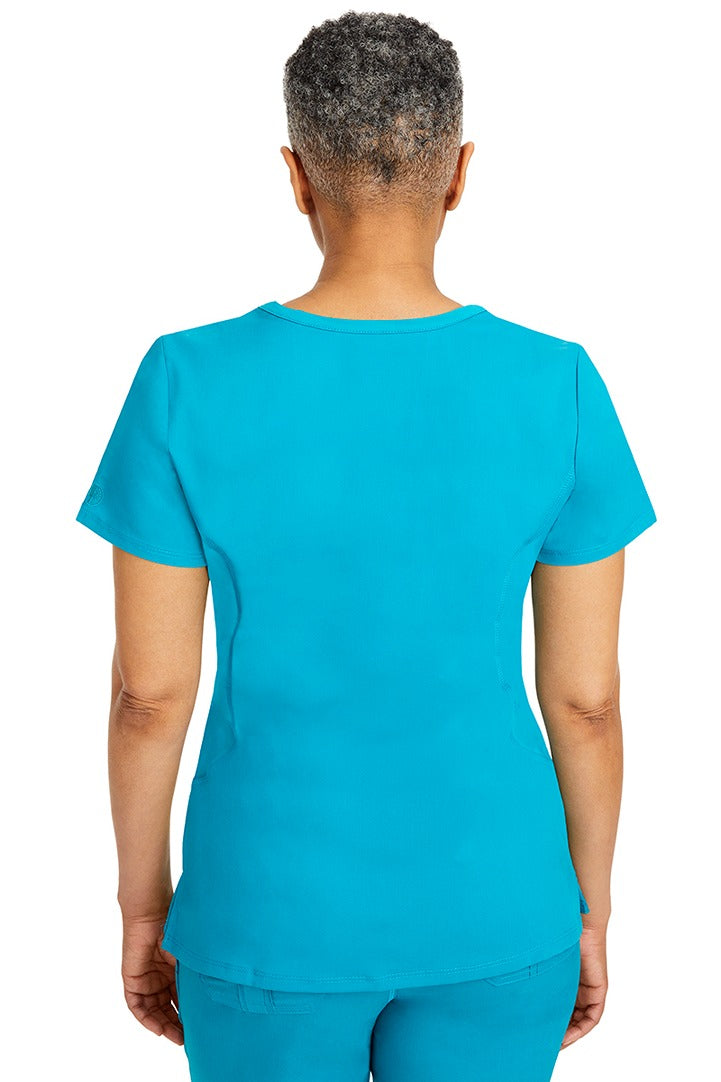 A female CNA wearing a Purple Label Women's Juliet Yoga Scrub Top in Teal featuring a medium center back length of 24".