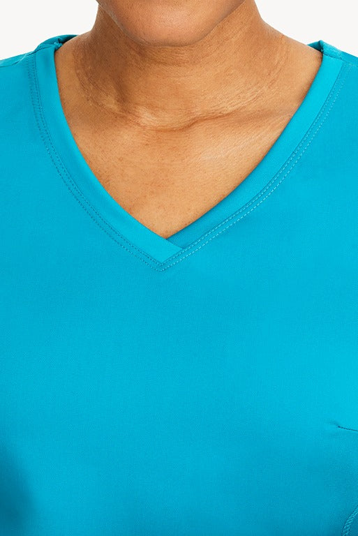 A young healthcare professional wearing a Purple Label Women's Juliet Yoga Scrub Top in Teal featuring a modern fit.