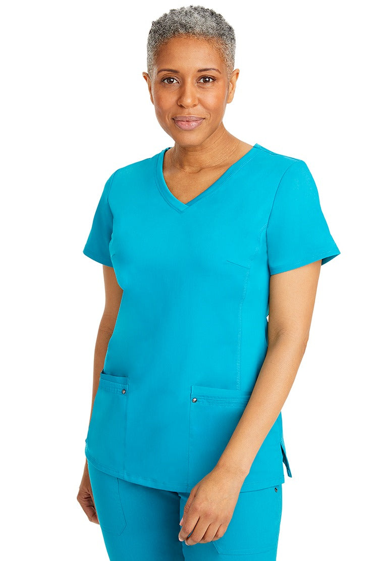 A lady nurse wearing a Purple Label Women's Juliet Yoga Scrub Top in Teal featuring a super comfortable stretch fabric made of 77% polyester/20% rayon/3% spandex.