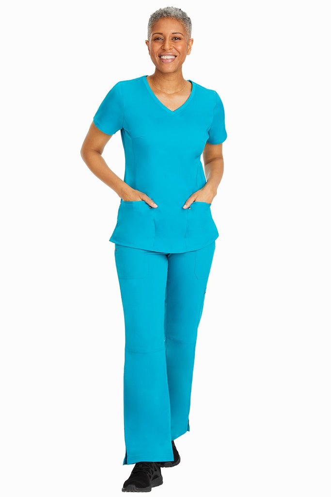 A young female nurse wearing a Purple Label Women's Juliet Yoga Scrub Top by Healing Hands in Teal featuring a v-neckline.