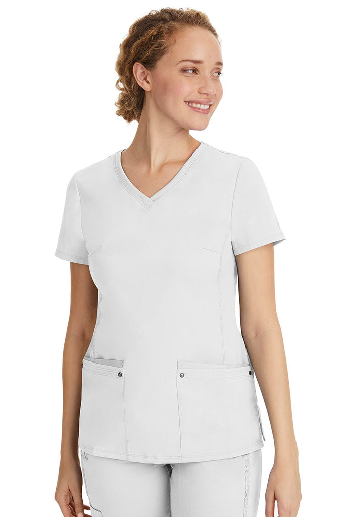 A female healthcare professional wearing a Women's Juliet Yoga Scrub Top from Purple Label in White  featuring a side stretch panels.