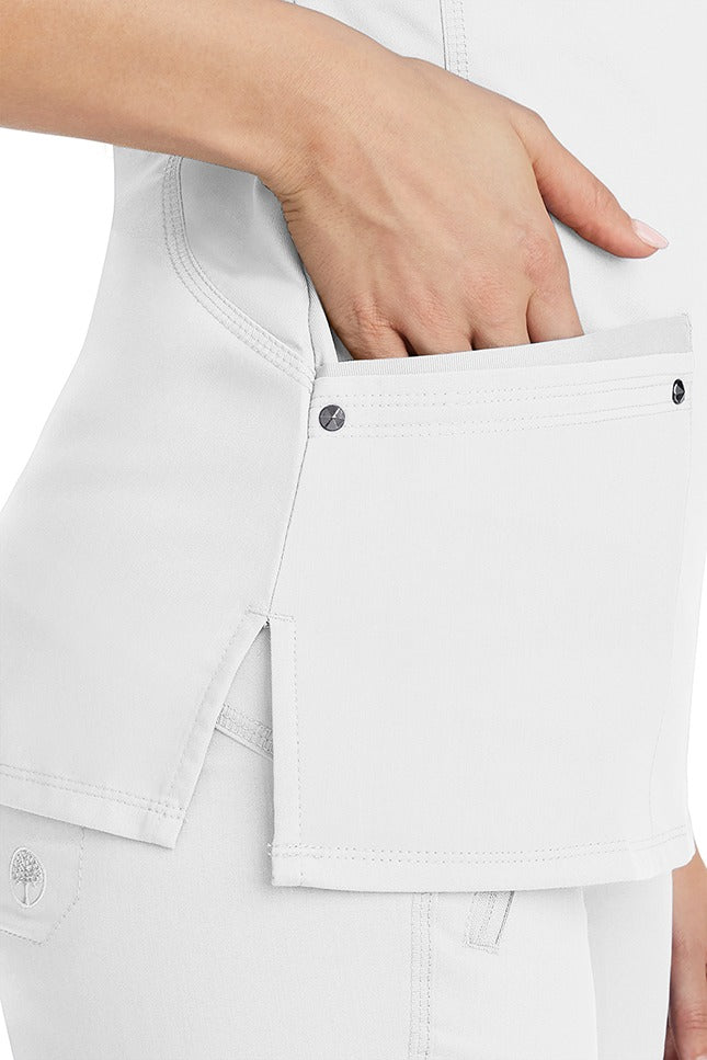 A young woman wearing a Women's Juliet Yoga Scrub Top from Purple Label by Healing Hands in White featuring side slits for additional range of motion.