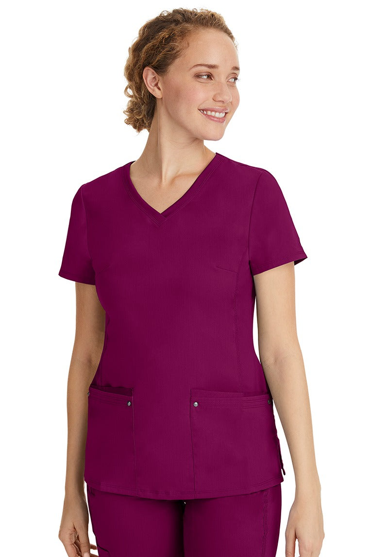 A lady nurse wearing a Purple Label Women's Juliet Yoga Scrub Top in Wine featuring a super comfortable stretch fabric made of 77% polyester/20% rayon/3% spandex.