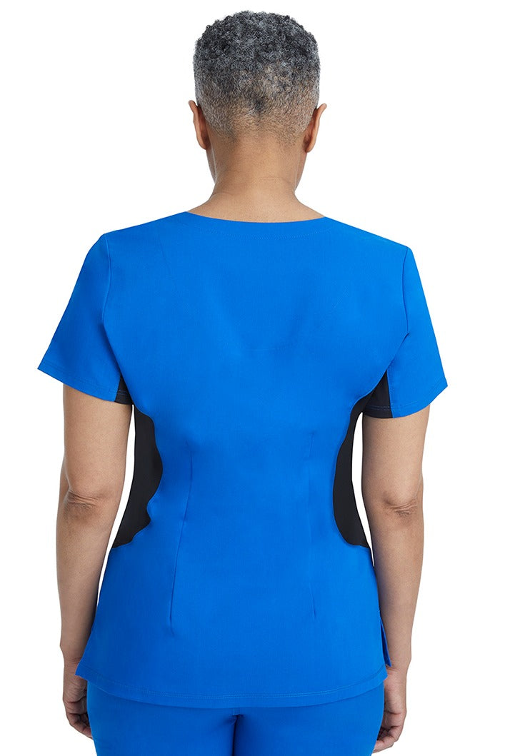 A female RN wearing a Purple Label Women's Jessi Y-Neck Scrub Top in Royal featuring a center back length of 26.5".