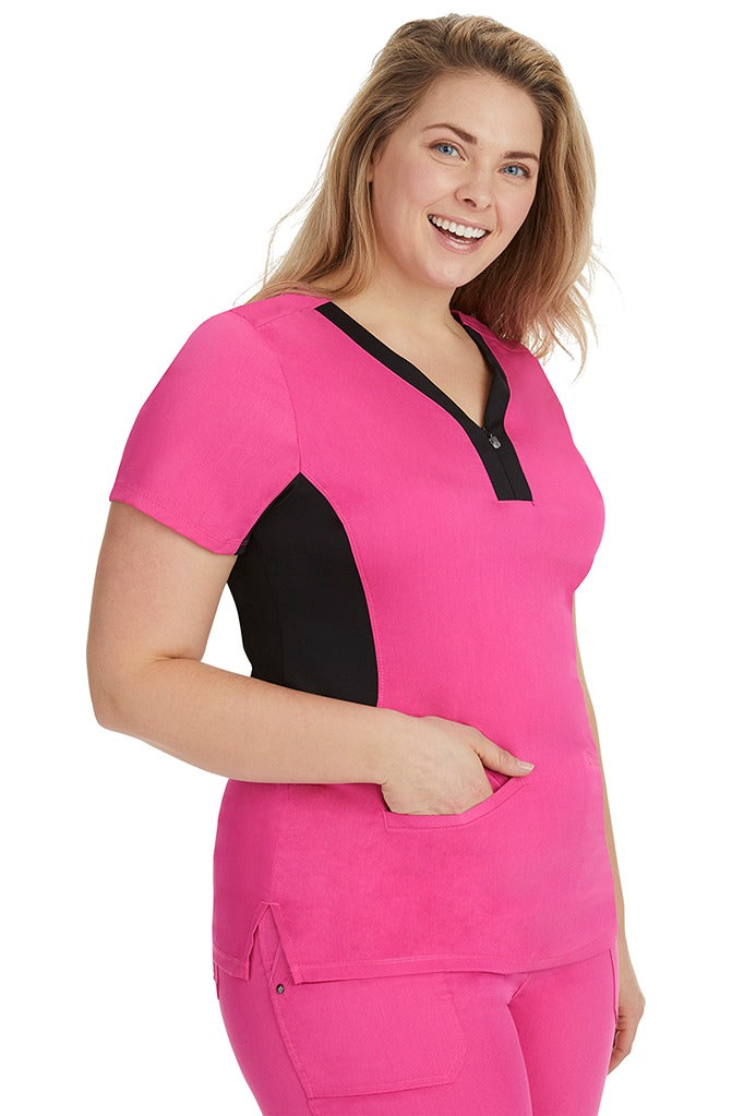 A female LPN wearing a Women's Jessi Y-Neck Scrub Top from Purple Label in Shocking Pink featuring a super comfortable stretch fabric made of 96% polyester & 4% spandex.