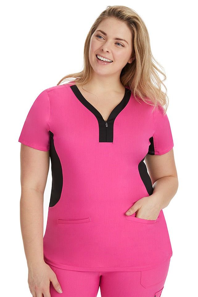 A home care registered nurse wearing a Purple Label Women's Jessi Y-Neck Scrub Top in Shocking Pink with Black Trim featuring 2 front patch pockets.