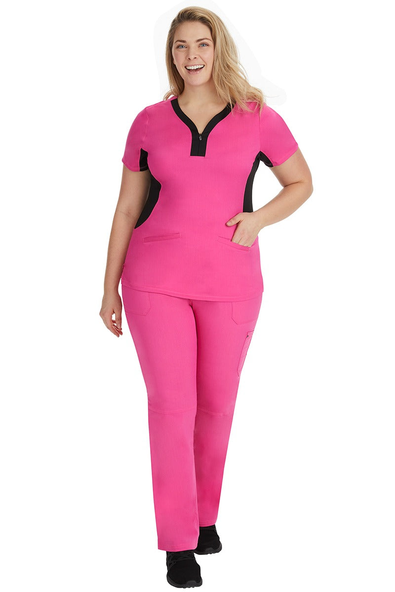 A female healthcare professional wearing a Purple Label Women's Jessi Y-Neck Scrub Top in Shocking Pink with Black Trim featuring short sleeves.