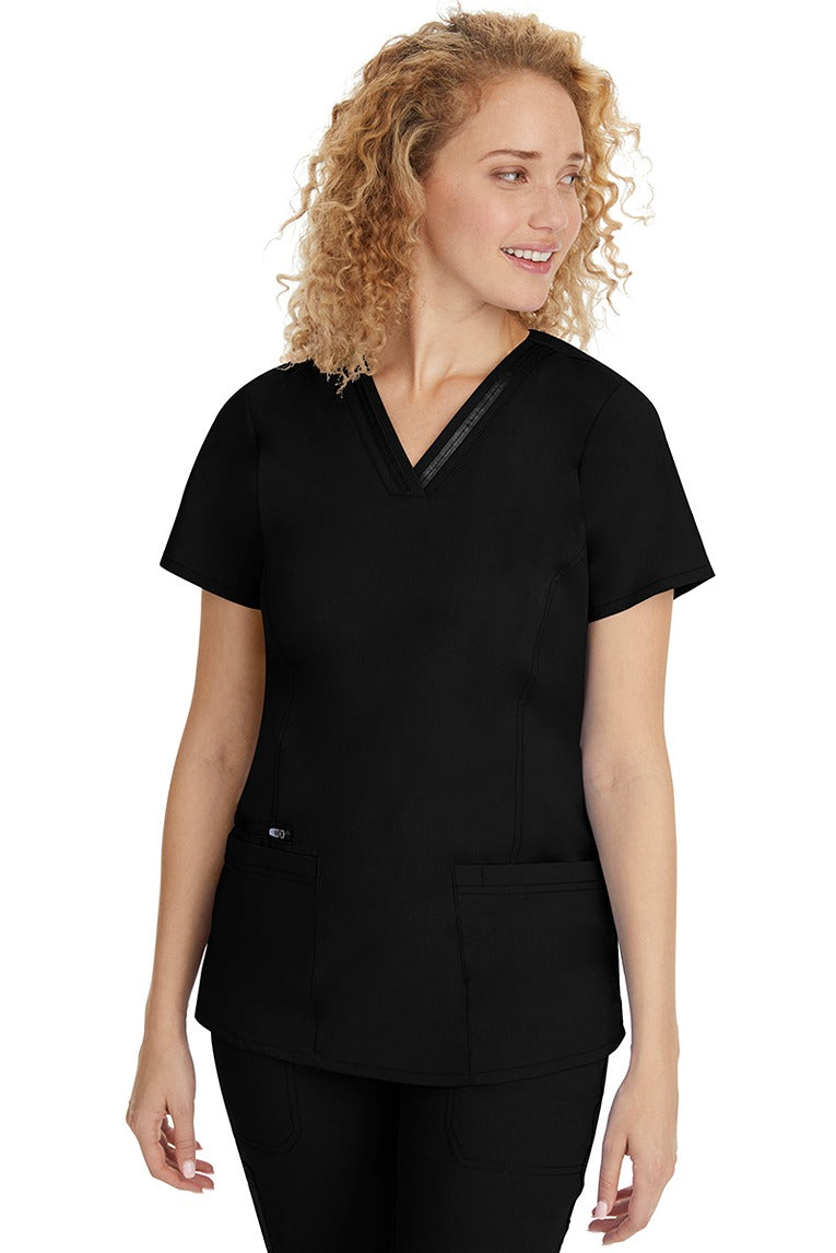 A young Home Care Registered Nurse wearing a Purple Label Women's Jasmin Fashion V-Neck Scrub Top in Black featuring front & back princess seams to provide a flattering fit.