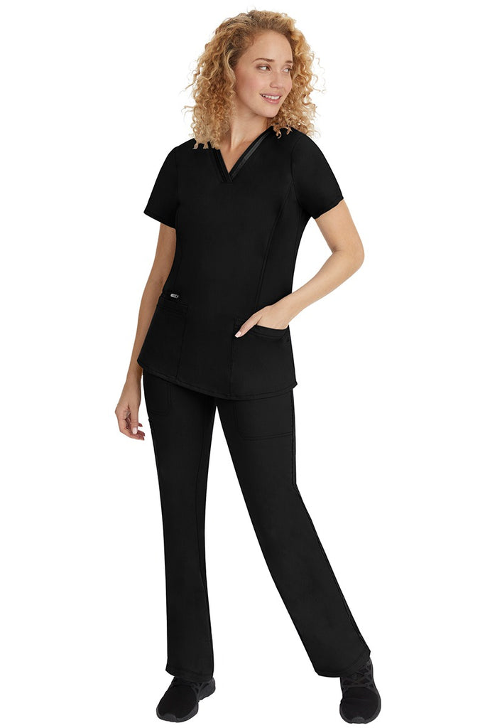 A young lady nurse wearing a Purple Label Women's Jasmin Fashion V-Neck Scrub Top in Black with a missy relaxed fit & short sleeves.