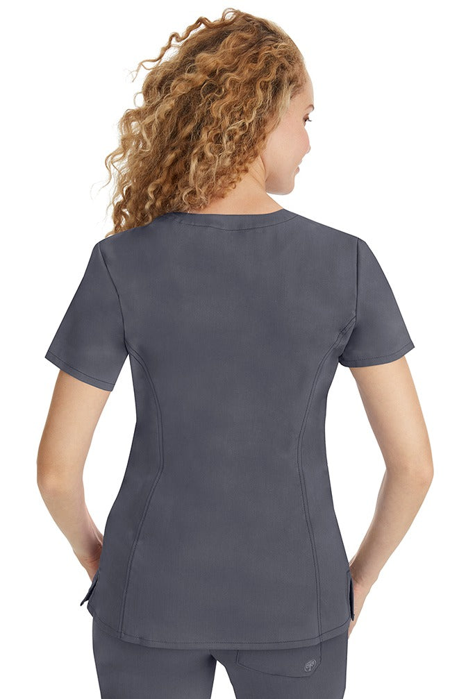 A young woman wearing a Purple Label Women's Jasmin Fashion V-neck Scrub Top in Pewter featuring a center back length of 25.5".