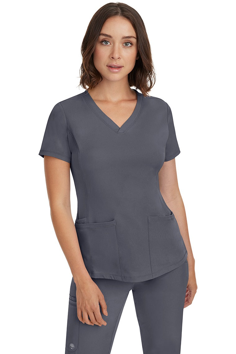 A female Nurse Practitioner wearing an HH-Works Women's Monica Multi-Pocket Scrub Top in Pewter featuring a total of 4 pockets.