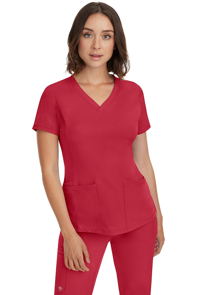 A female Nurse Practitioner wearing an HH-Works Women's Monica Multi-Pocket Scrub Top in Red featuring a total of 4 pockets.