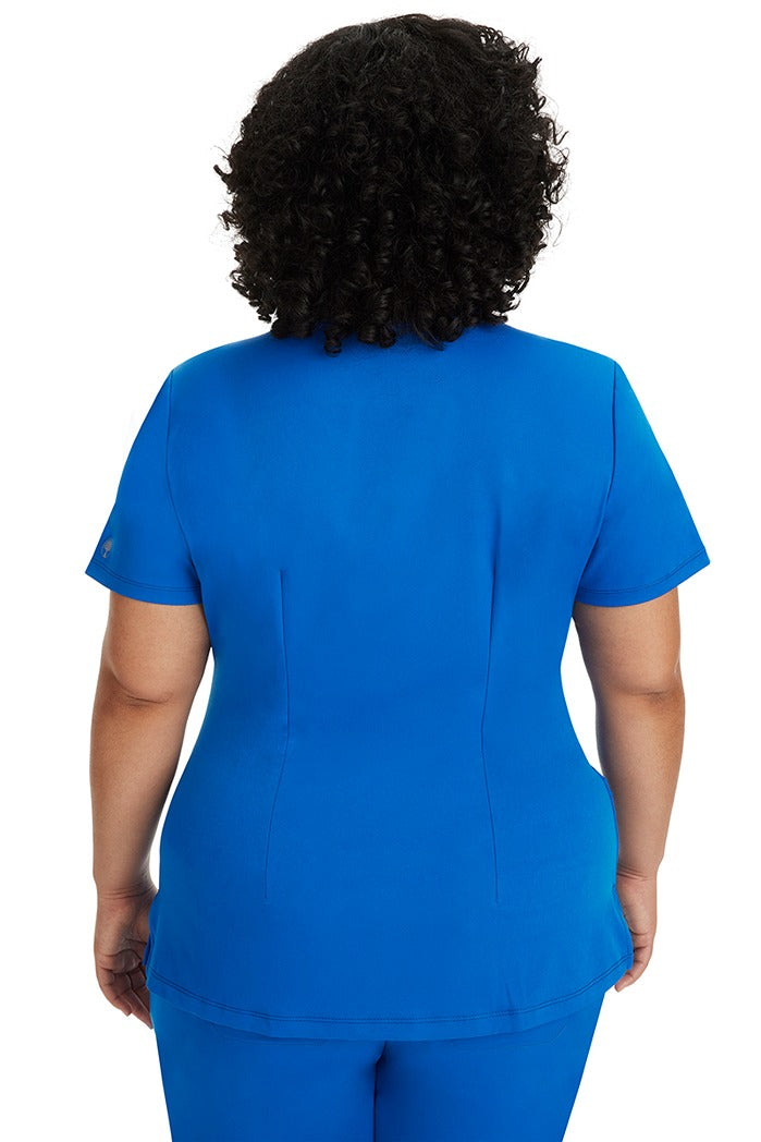 A female registered nurse wearing a Women's Monica Multi-Pocket Scrub Top from HH Works in Royal featuring back princess darts for shaping.