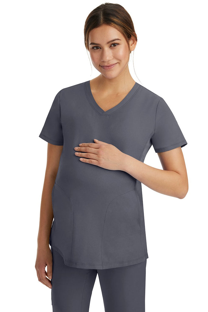 A female Home Care Registered Nurse wearing an HH-Works Women's Mila Maternity V-Neck Scrub Top in Pewter featuring a medium center back length of 27.5".