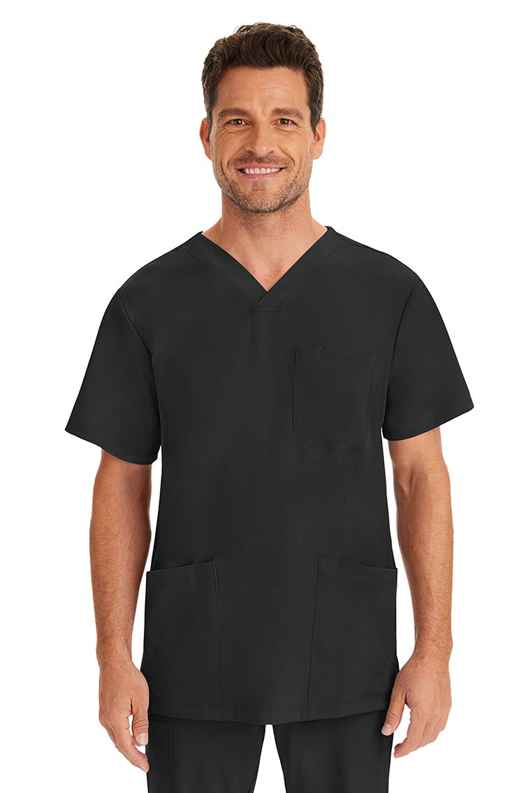 A young male nurse wearing an HH-Works Men's Matthew V-Neck Scrub Top in Black featuring a v-neckline & short sleeves.