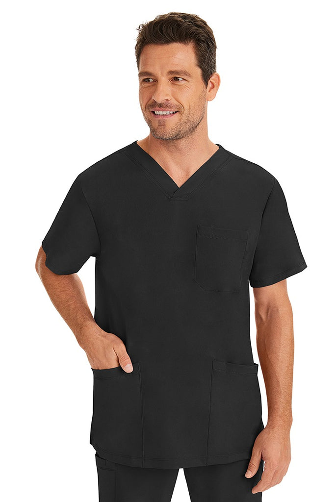 A male healthcare professional wearing an HH-Works Men's Matthew V-Neck Scrub Top in Black featuring a total of 4 pockets. for all your on the job storage needs.