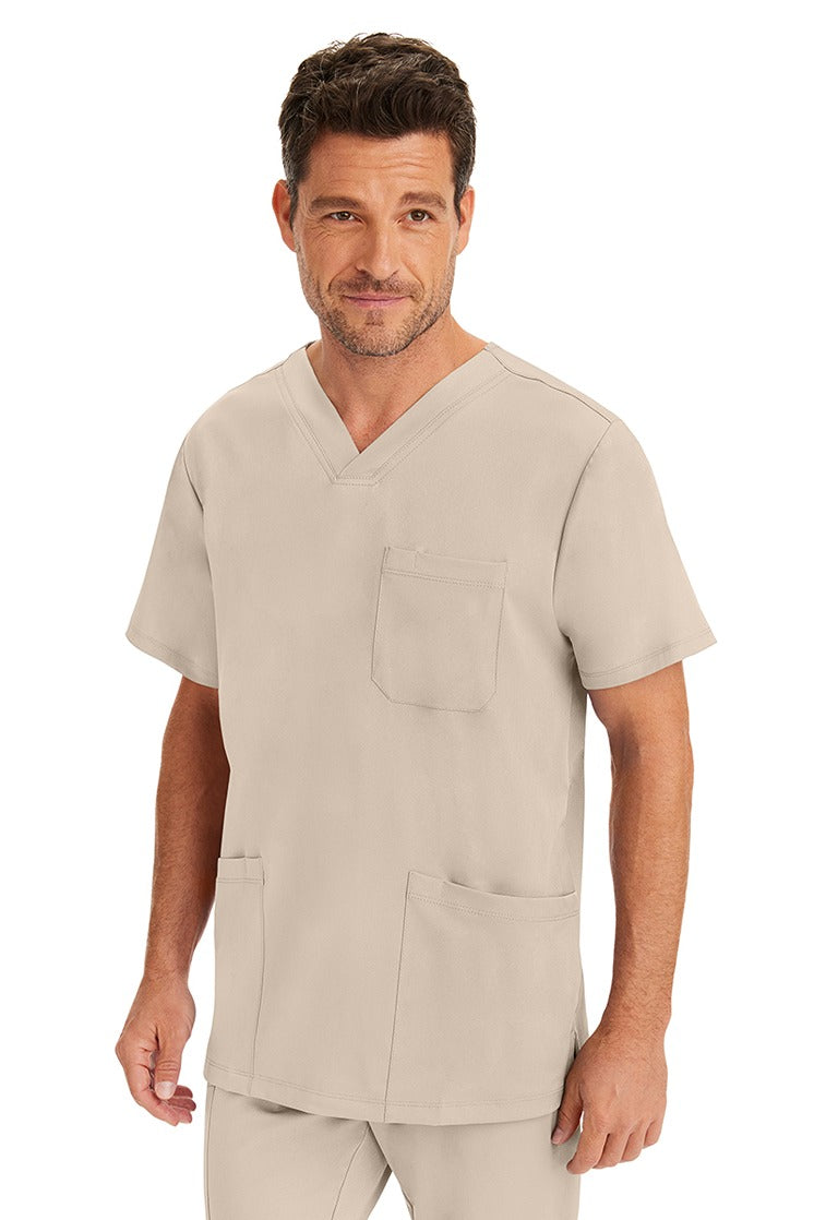 A male LVN wearing an HH-Works Men's Matthew V-Neck Scrub Top in Khaki featuring a unique 4 way stretch fabric.
