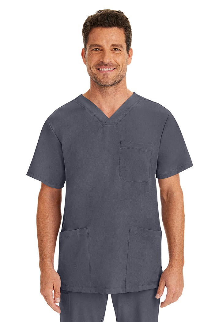 A young male nurse wearing an HH-Works Men's Matthew V-Neck Scrub Top in Pewter featuring a v-neckline & short sleeves.