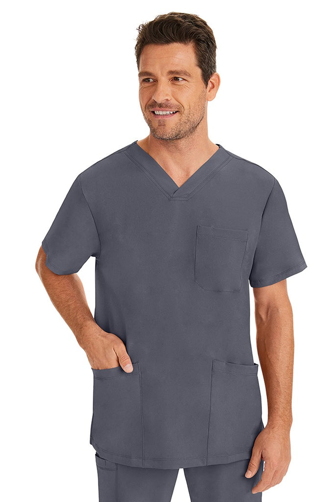 A male healthcare professional wearing an HH-Works Men's Matthew V-Neck Scrub Top in Pewter featuring a total of 4 pockets. for all your on the job storage needs.