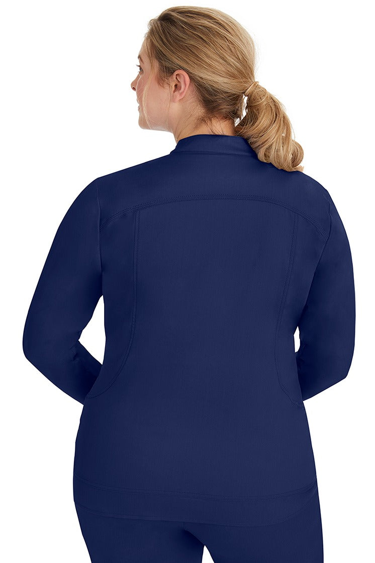 A young lady nurse wearing a Women's Dakota Zip Up Scrub Jacket from Purple Label by Healing Hands in Navy featuring stylish seaming throughout to ensure a flattering fit.