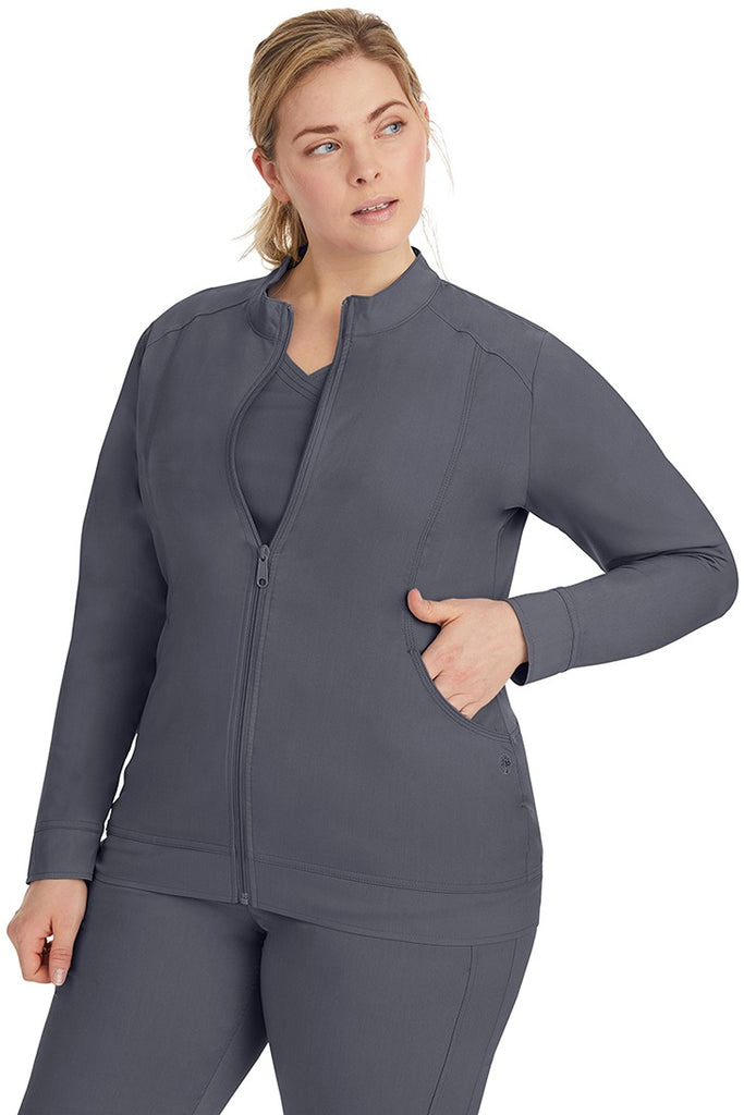 A young LPN wearing a Purple Label Women's Dakota Zip Up Scrub Jacket in Pewter featuring a super comfortable fabric made of 77% Polyester/20% Rayon/3% Spandex.