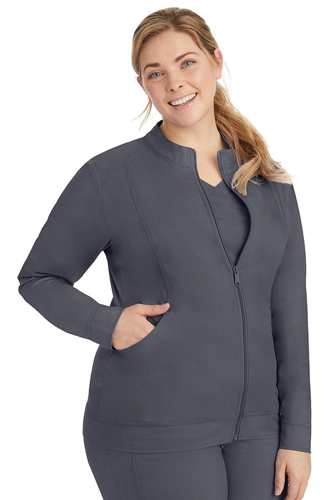 A young Home Care Registered Nurse wearing a Purple Label Women's Dakota Zip Up Scrub Jacket in Pewter featuring a zipper pull closure with opening for attaching ID.