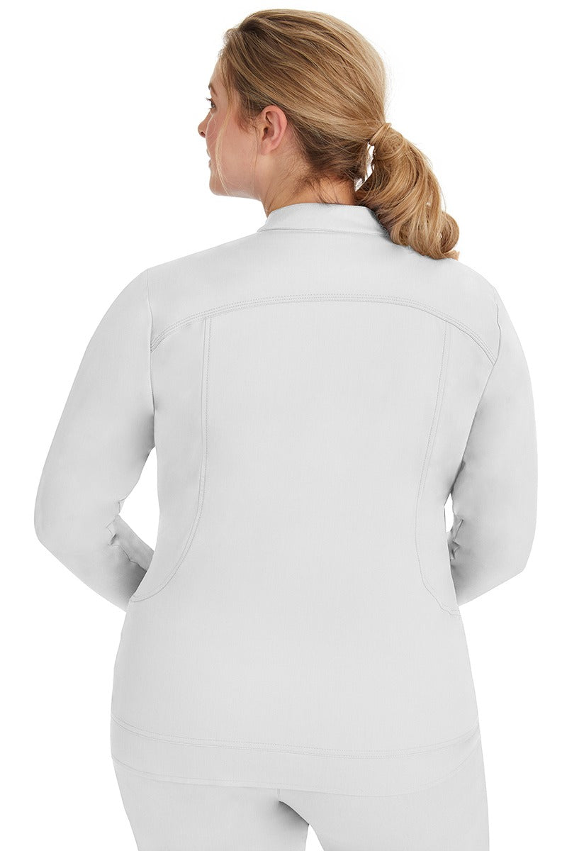 A young lady nurse wearing a Women's Dakota Zip Up Scrub Jacket from Purple Label by Healing Hands in White featuring stylish seaming throughout to ensure a flattering fit.