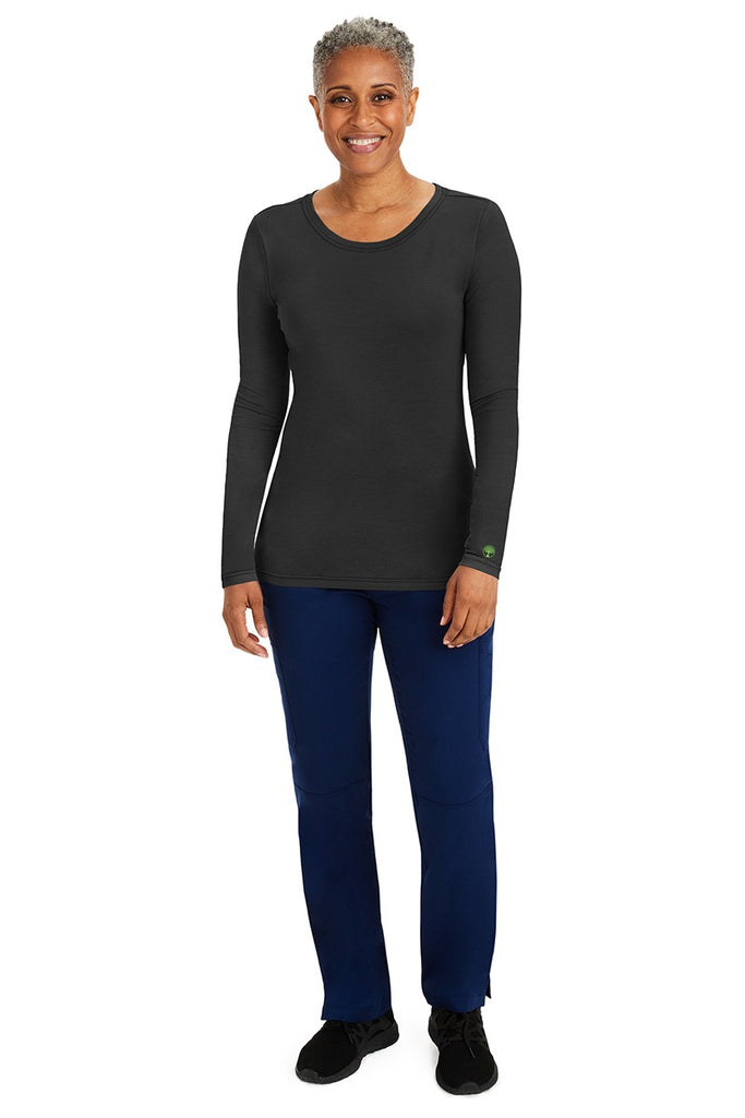 A female nurse wearing a Purple Label Women's Melissa Long Sleeve T-Shirt from Healing Hands in Black featuring a banded crew neckline.