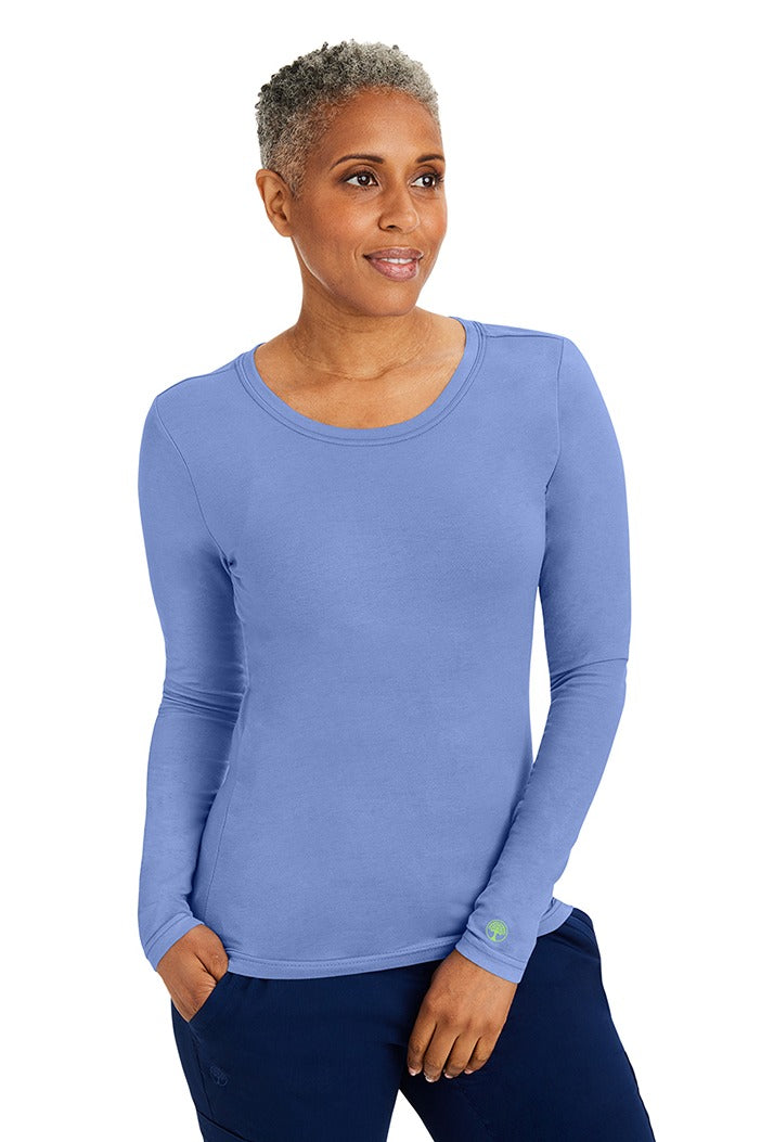 A young woman wearing a Purple Label Women's Melissa Long Sleeve T-Shirt from Healing Hands in Ceil featuring a modern fit & a shaped body.