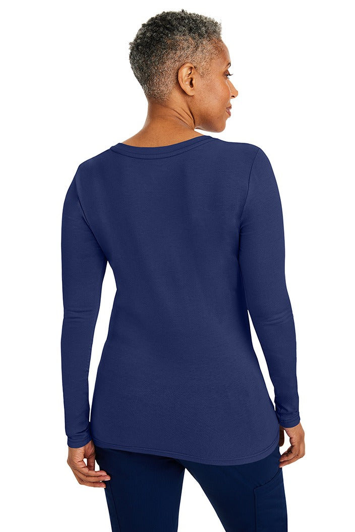 A woman Registered Nurse wearing a Purple Label Women's Melissa Long Sleeve T-Shirt in Navy featuring a a superior cotton-polyester-spandex stretch fabric blend that is lightweight, soft and breathable.