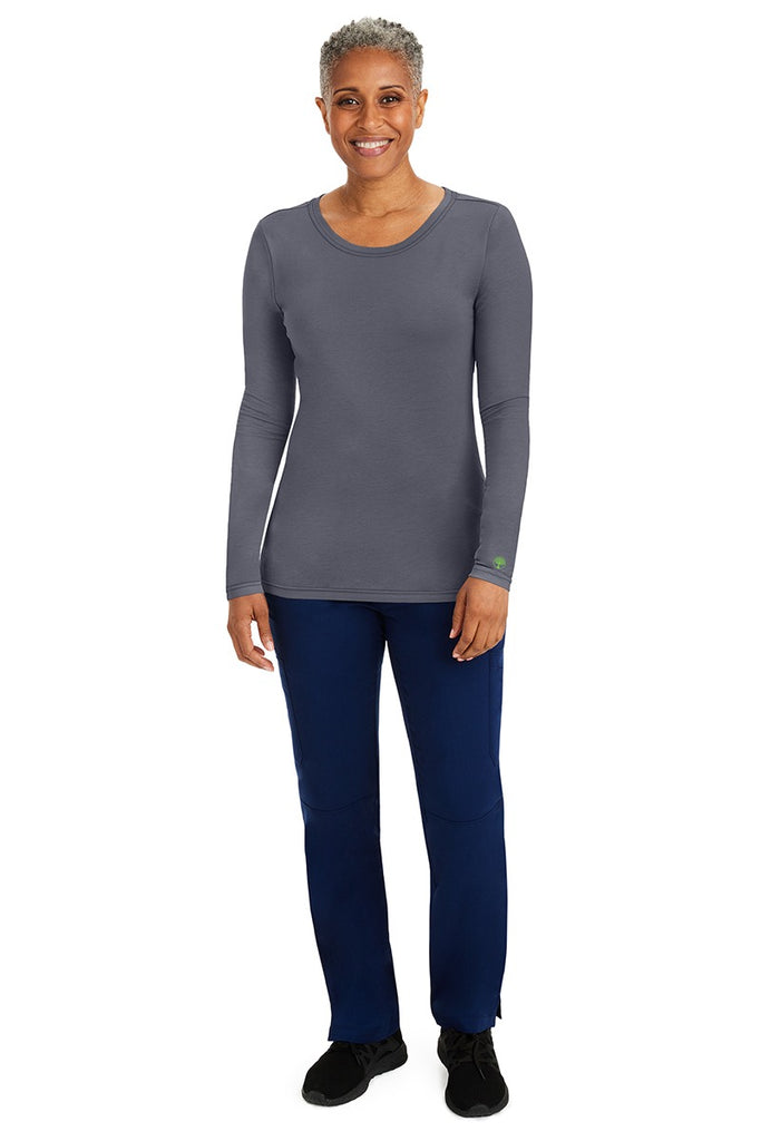 A female nurse wearing a Purple Label Women's Melissa Long Sleeve T-Shirt from Healing Hands in Pewter featuring a banded crew neckline.