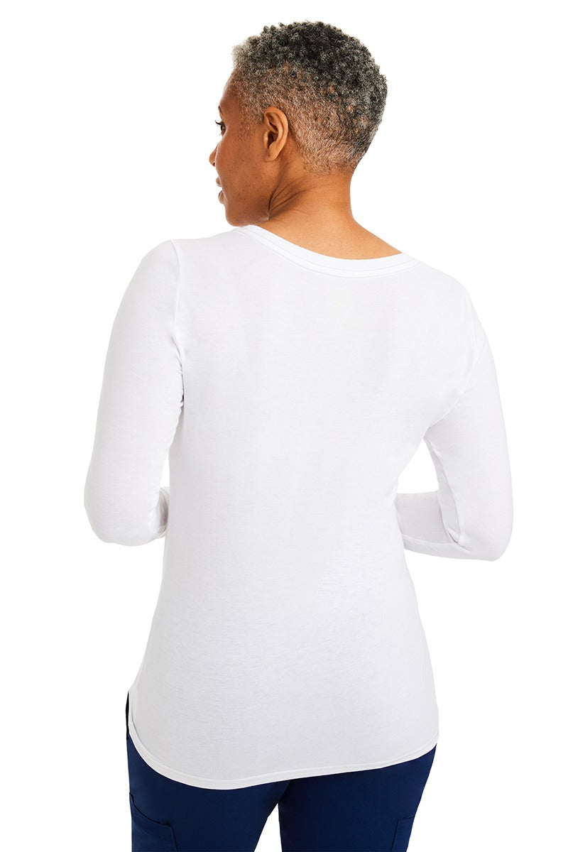 A lady CNA wearing a Purple Label Women's Melissa Long Sleeve T-Shirt in White featuring a slim fit to provide a flattering all day look.