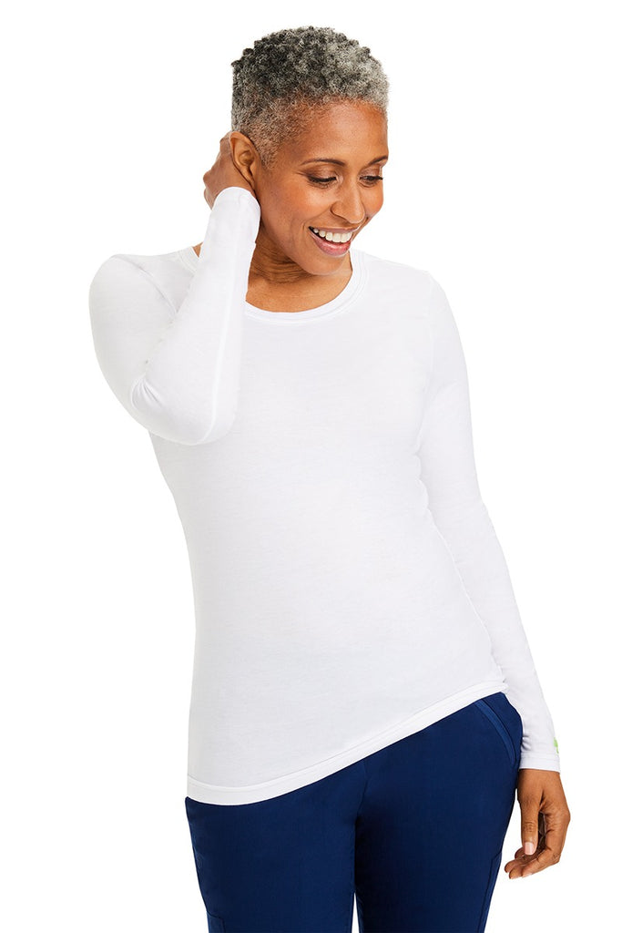 A woman Registered Nurse wearing a Purple Label Women's Melissa Long Sleeve T-Shirt in White featuring a a superior cotton-polyester-spandex stretch fabric blend that is lightweight, soft and breathable.
