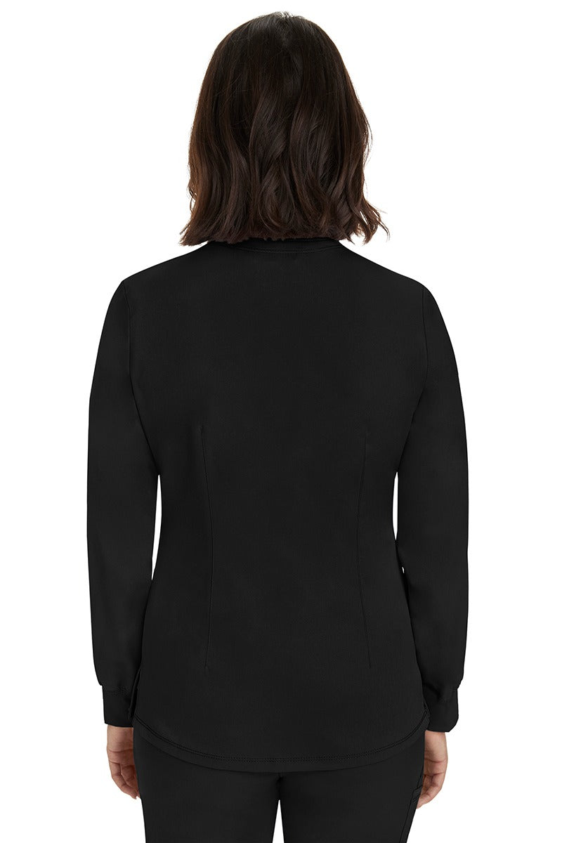 A young female Home Care Registered Nurse wearing an HH-Works Women's Megan Snap Front Scrub Jacket in Black featuring a medium center back length of 25.5".