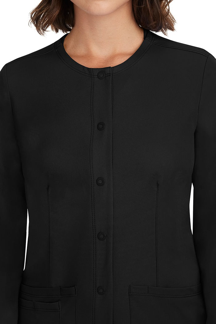 A female LPN wearing a Women's Megan Snap Front Scrub Jacket  from HH Works in Black featuring a snap-up button front closure.